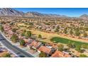 Aerial view of a community beside a golf course and mountain at 9524 Sundial Dr, Las Vegas, NV 89134