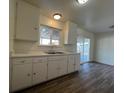 Kitchen with white cabinets, wood-look floors, and access to backyard at 120 Maple St, Henderson, NV 89015