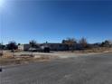 Mobile home with a gravel driveway and mountain views at 1851 Janet Ln, Pahrump, NV 89060