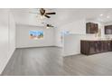 Open living room and kitchen area with gray vinyl flooring and ceiling fans at 5280 Plainview Ave, Las Vegas, NV 89122