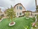 Landscaped backyard with artificial turf and covered patio at 8441 Sheltered Valley Dr, Las Vegas, NV 89128