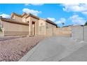 Two-story house with a beige exterior and gated driveway at 5200 White Coyote Pl, Las Vegas, NV 89130