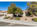 Single-story home with a tan exterior and mature trees at 8916 Desert Mound Dr, Las Vegas, NV 89134