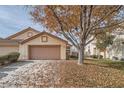 House exterior with a two-car garage and autumn leaves on the lawn at 1115 Scenic Crest Dr, Henderson, NV 89052