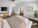 Virtually staged main bedroom with a large bed and ensuite bathroom at 1658 Garden Path Ct, Las Vegas, NV 89119