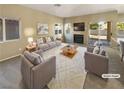 Virtually staged living room with gray sofas and a fireplace at 256 Camelback Ridge Ave, Henderson, NV 89012