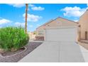 Single-story house with a white garage door and landscaped front yard at 8221 Ten Gallon Ct, Las Vegas, NV 89129