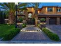 Inviting entryway with a paved pathway, wrought iron gate, and landscape lighting at 1504 Castle Wall St, Las Vegas, NV 89117