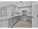 Modern kitchen with white and gray cabinets and quartz countertops at 10731 Mason Hill Ave, Las Vegas, NV 89166