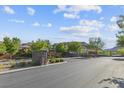 Gated community entrance with landscaping and mountains in the background at 10554 Cloud Whisper Dr, Las Vegas, NV 89135