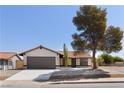 Single story home with a brown garage door and landscaped yard at 110 Palo Verde Dr, Henderson, NV 89015