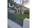 House exterior with a grassy yard, mature trees, and a blue metal fence at 4705 Rockvale Dr, Las Vegas, NV 89103