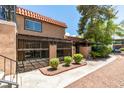 Tan condo building with red tile roof and a gated patio area at 200 Brookside Ln # C, Las Vegas, NV 89107