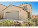 Beige two-story house with a green door and attached garage at 3537 Quiet Pueblo St, North Las Vegas, NV 89032