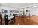 Open living space with hardwood floors, white sofa, and a marble dining table at 7954 Blue Venice Ct, Las Vegas, NV 89117