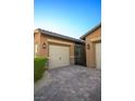 Two-car garage with paver driveway and wrought iron gate at 342 Torrelli Falls Ave, Henderson, NV 89011