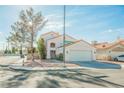 Two-story house with tile roof, attached garage, and front yard landscaping at 6501 Old Oxford Ave, Las Vegas, NV 89108