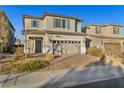 Two story house with gray siding, tan garage door, and a brick paver driveway at 1016 Greyhound Ln, Henderson, NV 89015