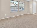 Spacious living room with neutral carpeting and large windows at 9539 Brewing Cloud Ave, Las Vegas, NV 89148