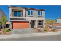 Two-story house with orange garage door and landscaped front yard at 8749 Black Cordon Rd, Las Vegas, NV 89139