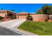 Tan stucco house with a double car garage and a nicely landscaped front yard at 437 Via Ventana Dr, Mesquite, NV 89027