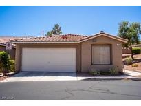 Tan single-story home featuring a two-car garage and low maintenance desert landscaping at , Henderson, NV 89014