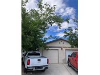 Two-car garage with white door and landscaping at 5618 Big Sea St # 5618, Las Vegas, NV 89110