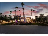 Modern home exterior at twilight with palm trees, landscaping, and uplighting at 7880 Dana Point Ct, Las Vegas, NV 89117