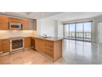 Modern kitchen with light wood cabinets and granite countertops at 322 Karen Ave # 2003, Las Vegas, NV 89109