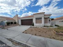 Single story home with brown garage door and front yard at 9820 Cross Creek Way, Las Vegas, NV 89117