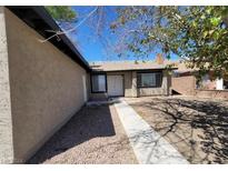 Tan single story home with walkway and landscaping at 3755 Chutney St, Las Vegas, NV 89121