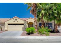 Single-story house with a two-car garage, landscaping, and desert landscaping at 3516 Barrel Race Ct, North Las Vegas, NV 89032