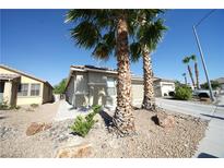 Tan house with a two-car garage and palm trees at 6040 Eganridge Ct, North Las Vegas, NV 89081