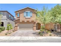 Two-story house with tan exterior, neutral garage door, and landscaping at 8620 Sparrow Desert Ave, Las Vegas, NV 89148