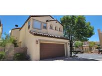 Two-story house with brown garage door and landscaped yard at 12064 Avery Meadows Ave, Las Vegas, NV 89138