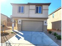 Two-story house with attached garage and landscaping at 645 Moonbeam Way, Mesquite, NV 89027