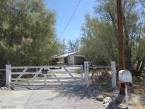 Ranch style home with white fence and gate at 147 S Leslie St, Pahrump, NV 89048