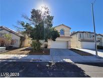 Two-story house with attached garage and mature tree in front yard at 7817 Falconwing Ave, Las Vegas, NV 89131