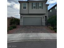 Two-story house with gray siding, two-car garage, and paved driveway at 1630 Harvest Pecan Ct, Las Vegas, NV 89108