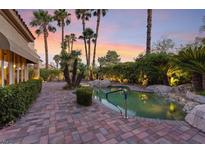 Sunset view of backyard oasis with inviting pool and patio at 8199 Pinnacle Peak Ave, Las Vegas, NV 89113