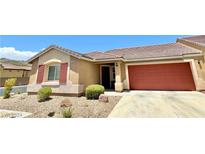 Tan house with red garage door and landscaping at 2820 China Cove St, Laughlin, NV 89029