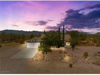 House with desert landscape, two-car garage, and mountain views at 2441 Ottawa St, Sandy Valley, NV 89019