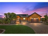 Mountain home exterior at dusk with solar panels at 150 Wind Drift Pl, Cold Creek, NV 89124