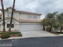 Three-car garage and two-story home with landscaping and palm trees at 9758 Camino Capistrano Ln, Las Vegas, NV 89147
