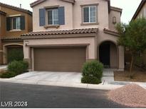 Two-story house with brown garage door and landscaping at 7510 Perla Del Mar Ave, Las Vegas, NV 89179