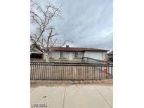 House front with a lawn, and black metal fence at 915 Major Ave, Henderson, NV 89015