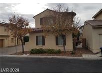 Tan two-story home with backyard access and landscaping at 1023 Sunny Acres Ave, North Las Vegas, NV 89081