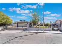 House exterior with a gated driveway and well-maintained lawn at 321 Agora Way, Las Vegas, NV 89110