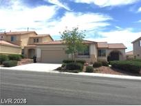 Single-story house with a two-car garage and landscaped yard at 6420 Indian Peak Ct, North Las Vegas, NV 89084