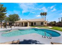 Inviting kidney-shaped pool with a spa and pergola at 6356 Canyon Ridge Dr, Las Vegas, NV 89108